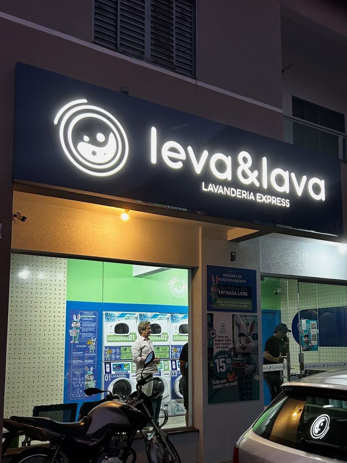Letra caixa iluminada em fachada de lavanderia. À noite é a luz que vende o ponto.