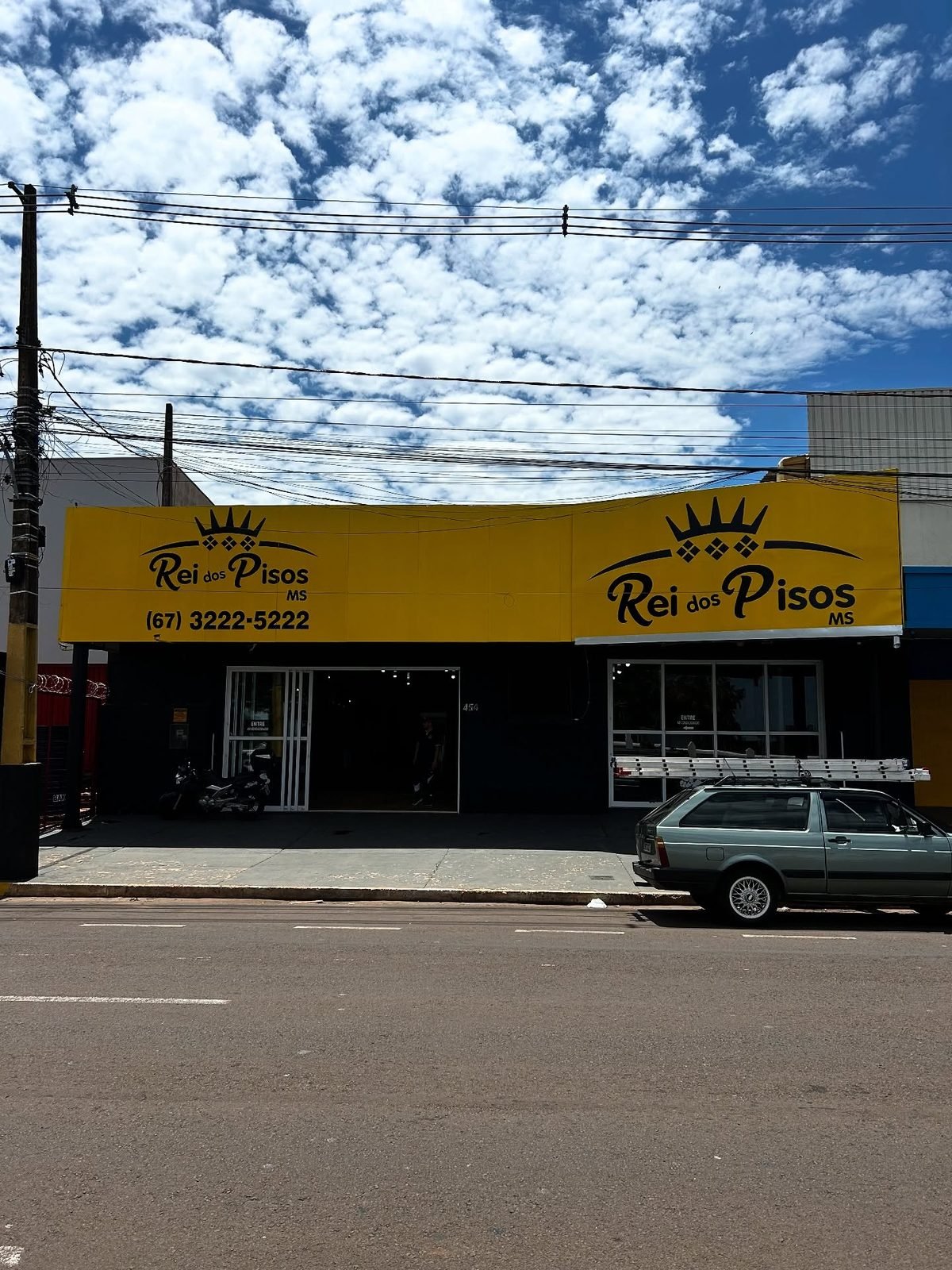 Fachada em ACM amarelo da Rei dos Pisos MS, instalada pela Arce, vista da rua em dia de sol